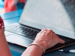 hands typing on laptop keyboard
